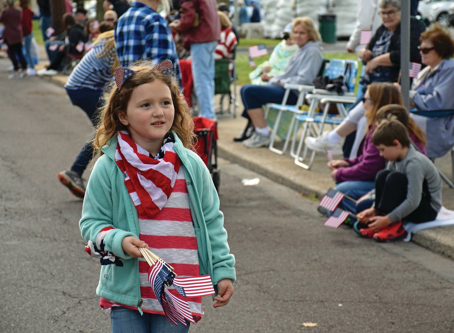 A young participant carries flags to give away.