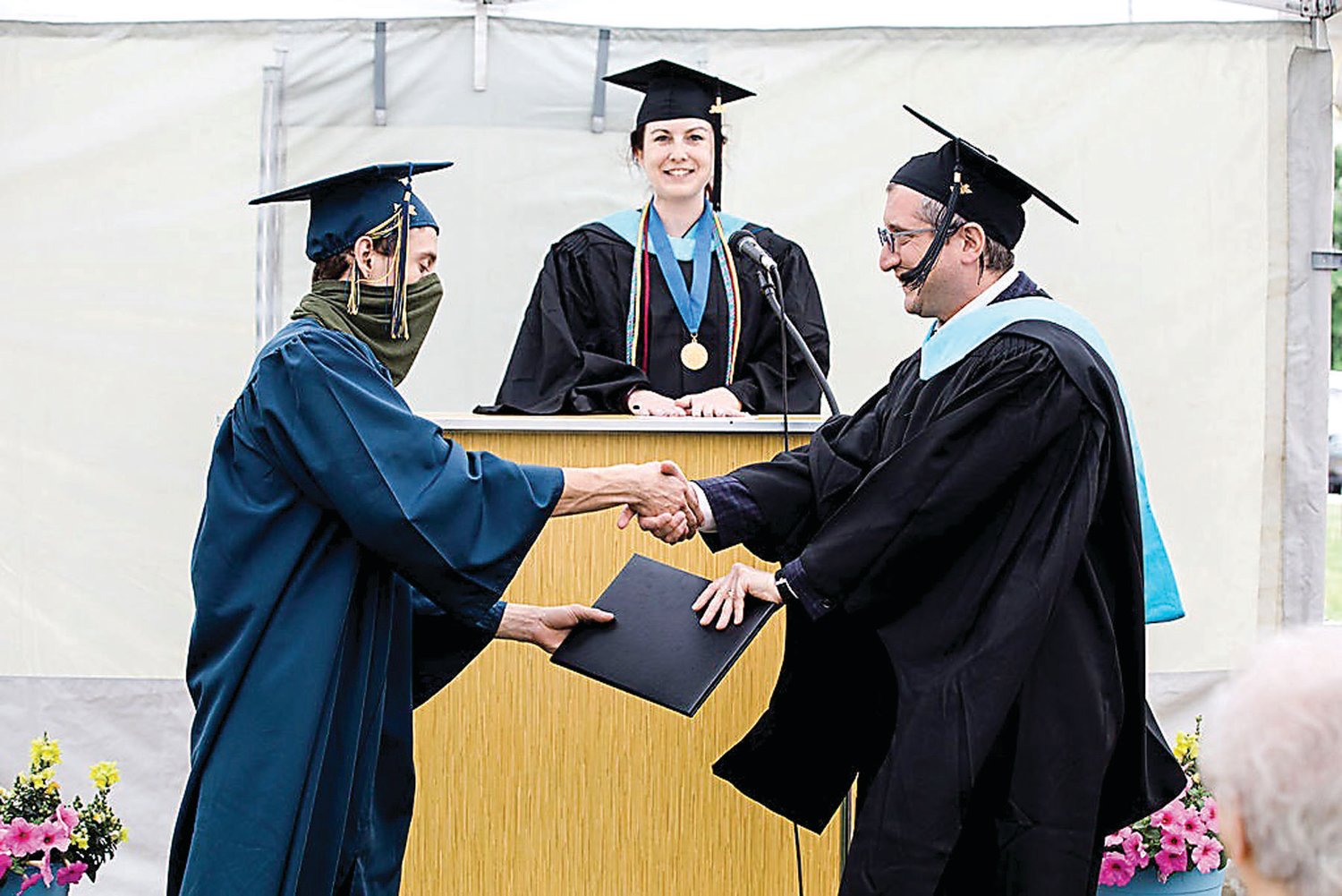 The first high school graduate of The Quaker School at Horsham, Sam Gerhart, shakes hands and receives his high school diploma from Alex Brosowsky, head of school, and Nicole Schwartz, Upper School director.