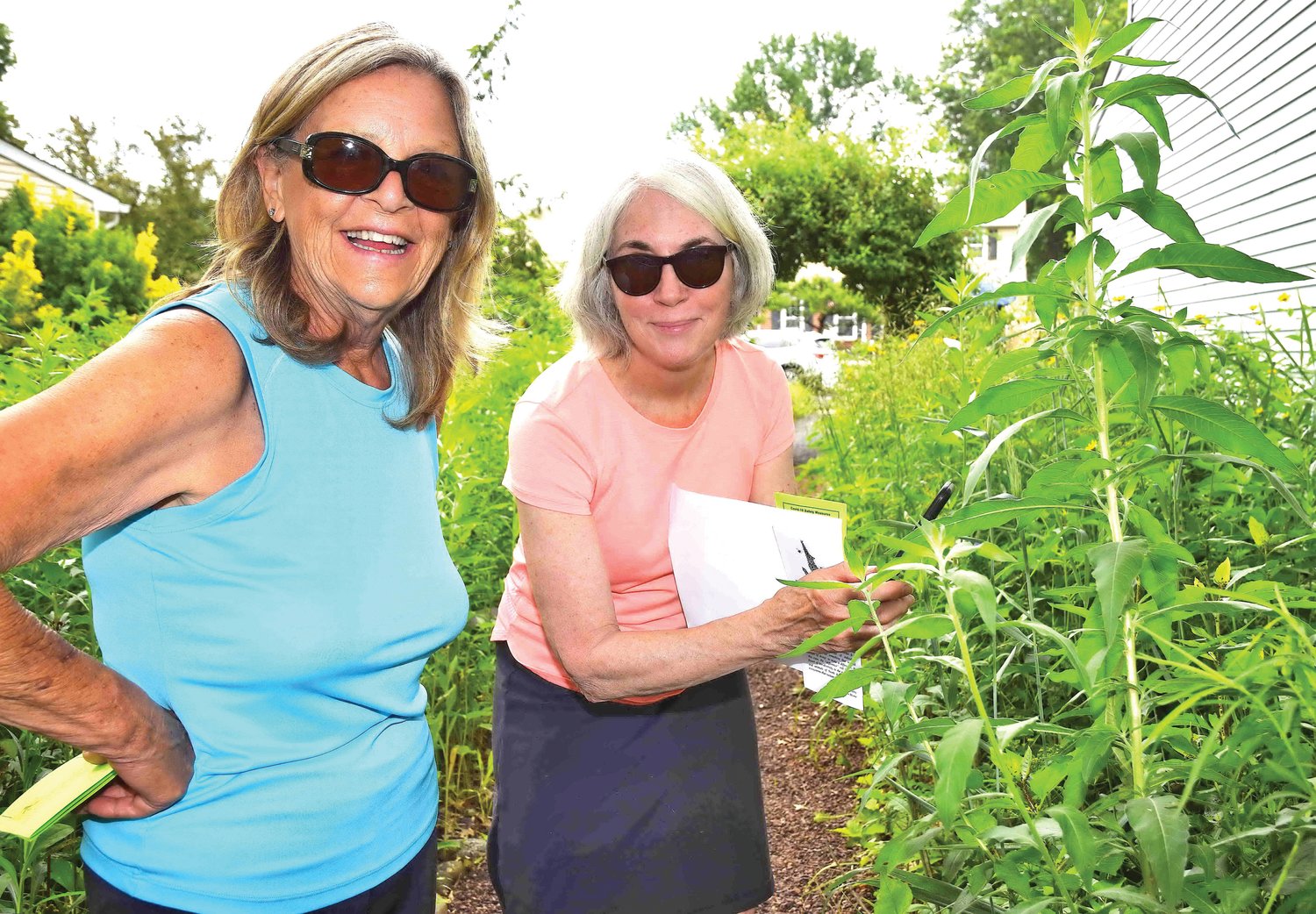 Susan Santoro and Carol Fischer admire flowers in the Jones garden.