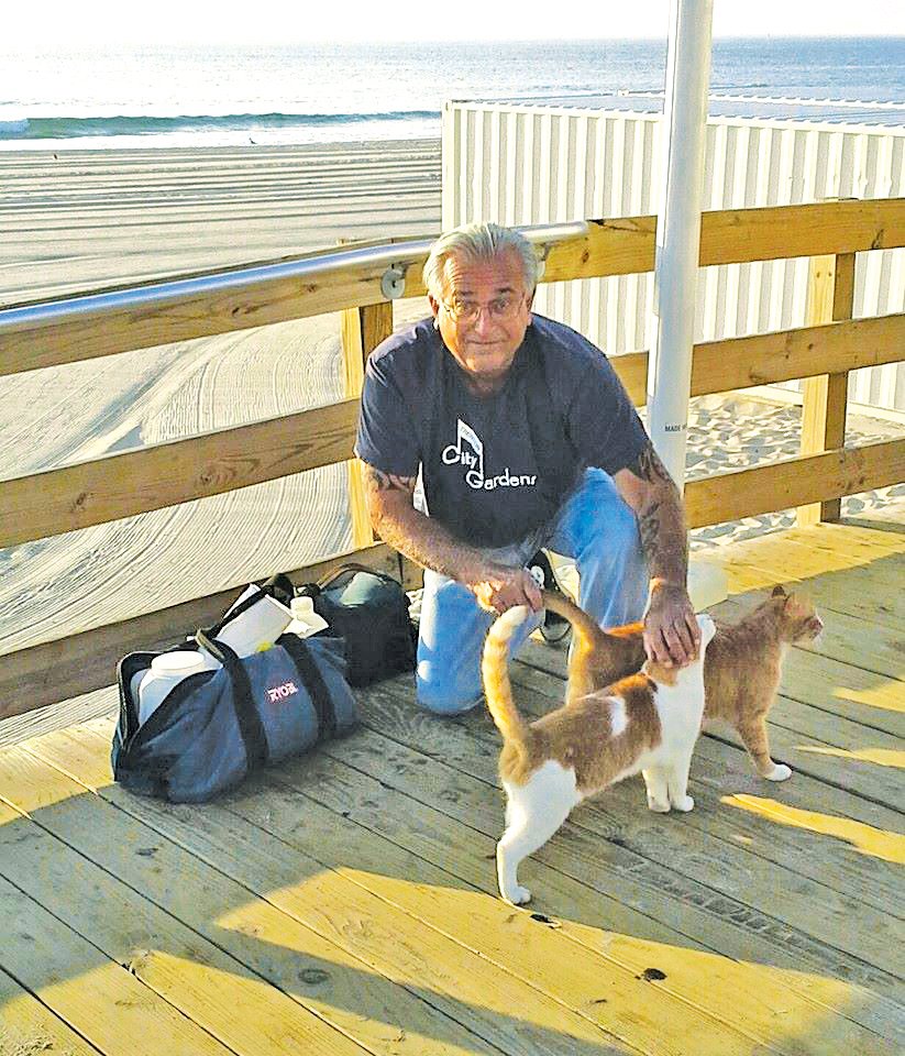 New Jersey’s Ken Salerno, visiting with two cats on the boardwalk, is among the cat colony caretakers featured in “Catnip Nation.”