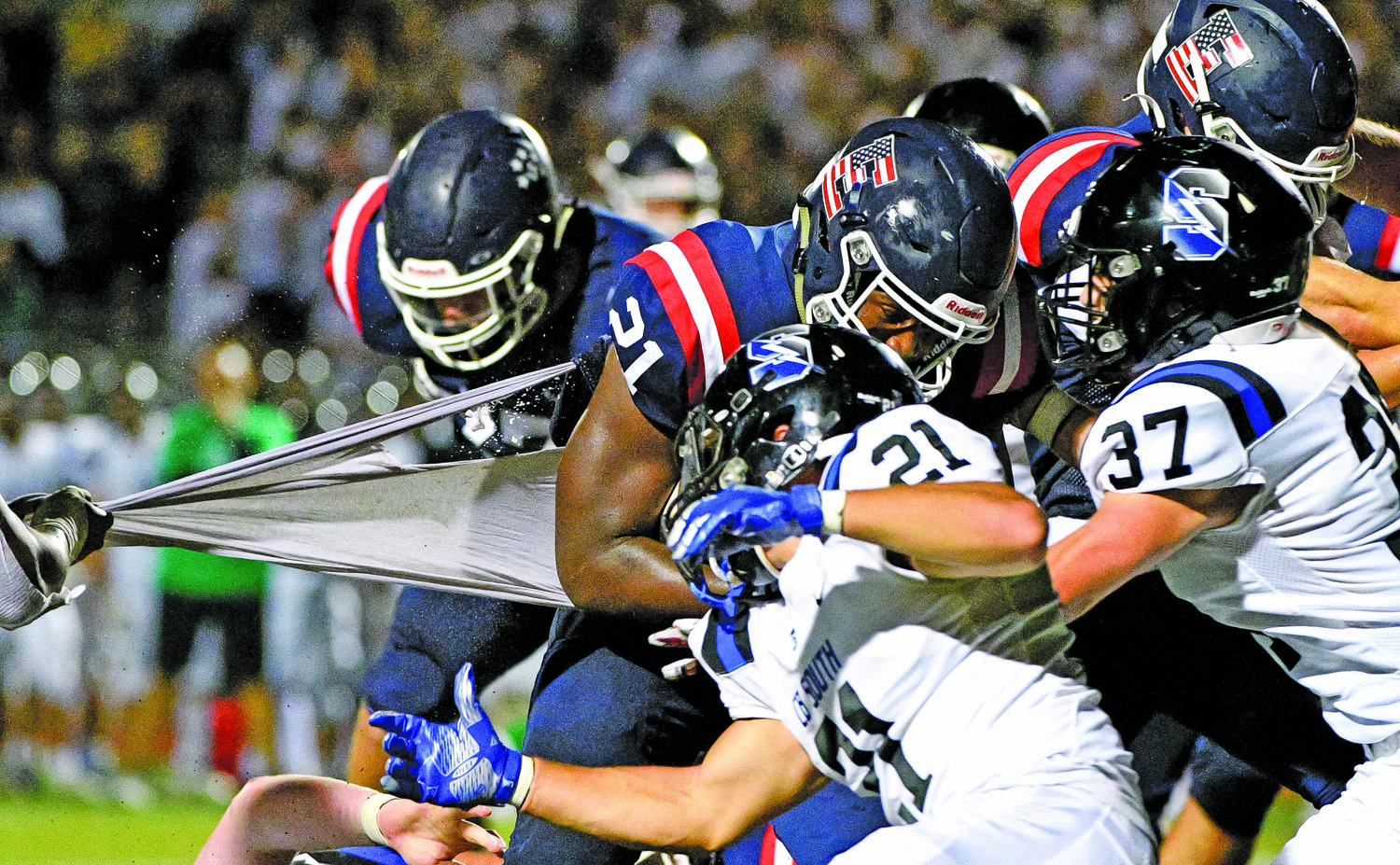 CB East’s Ethan Shine loses his shirt while being tackled by CB South’s Sebastian Pacchione and Devlin Carey.