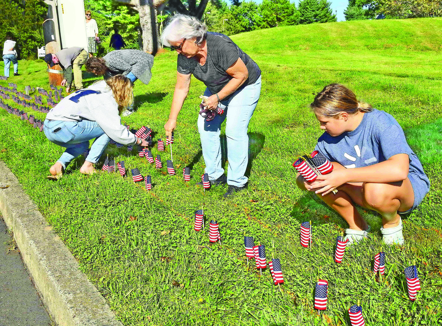 Members places flags along the property line of The Crossing in Washington Crossing.