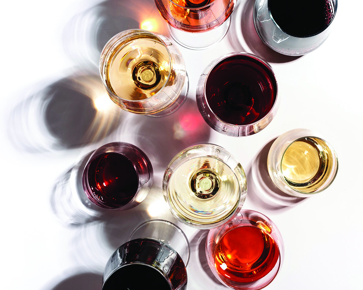 Red, rose and white wine in glasses on white background, top view.