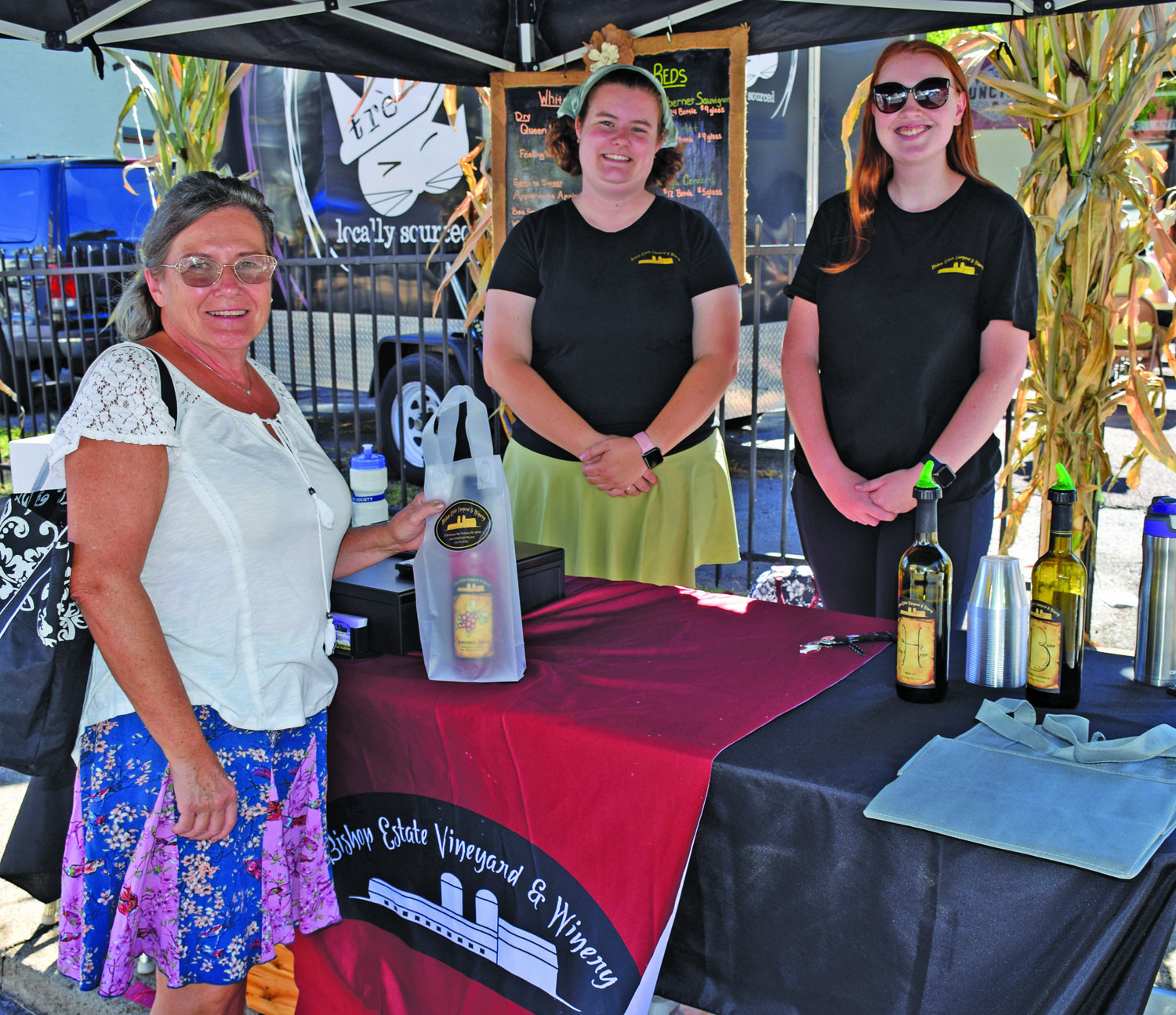 Barbara Ziet of New Hope purchases wine from Sarah Witherow and Rebecca Harman of Bishop’s Estate Winery.