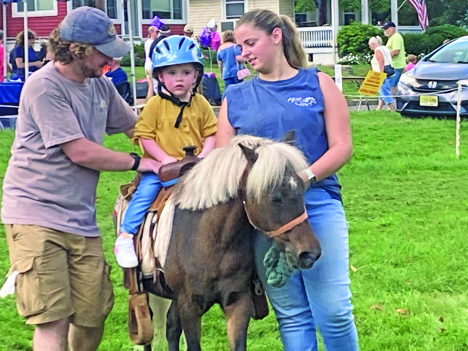 Madison Moleski, 2, of Fairless Hills enjoys a pony ride at Harvest Day in Yardley Borough. Guiding the mount is Jason Mulligan, left, and Madison Zuczek of Keona Farms in Stockton, N.J.