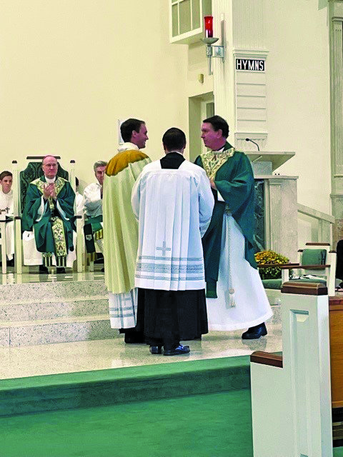 Newly installed Our Lady of Mt. Carmel pastor, the Rev. Matthew W. Guckin,  receives congratulations from the Rev. David P. O’Brien, in residence, OLMC; and the Rev. Matthew D. Brody, parochial vicar, OLMC.
