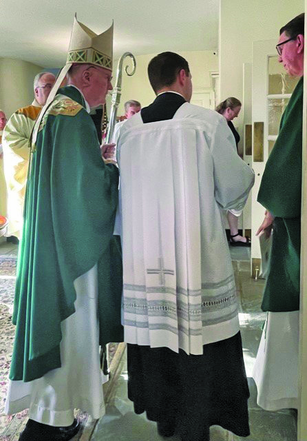 From left are the Most Rev. Michael J. Fitzgerald, auxiliary bishop of Philadelphia; the Rev. Matthew D. Brody, parochial vicar, OLMC; and the Rev. Matthew W. Guckin, pastor, OLMC, during the blessing and presentation of the Parish Keys in the church narthex prior to the opening of Mass.