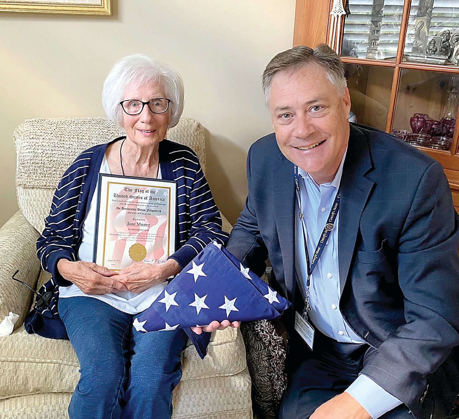 Christ’s Home CEO John Bryant presents June Mauer with a plaque and flag from U.S. Rep. Brian Fitzpatrick.