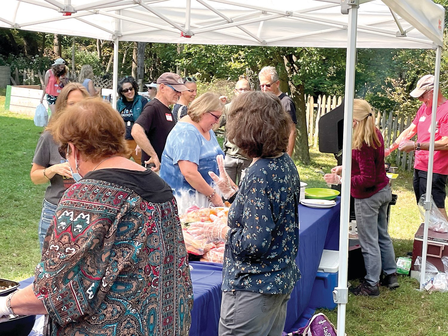Members line up for the picnic fare of barbecue, salads and desserts.