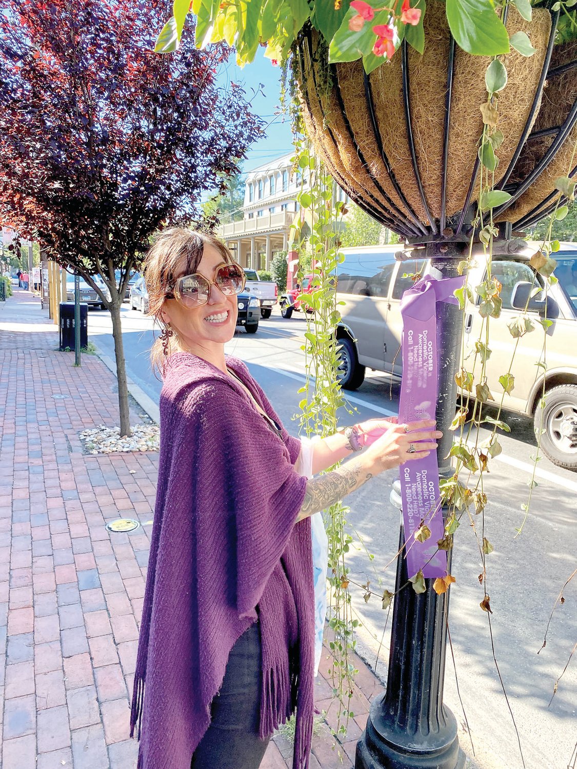 Patricia Walker ties a purple ribbon in New Hope that raises awareness for Domestic Violence Awareness Month.