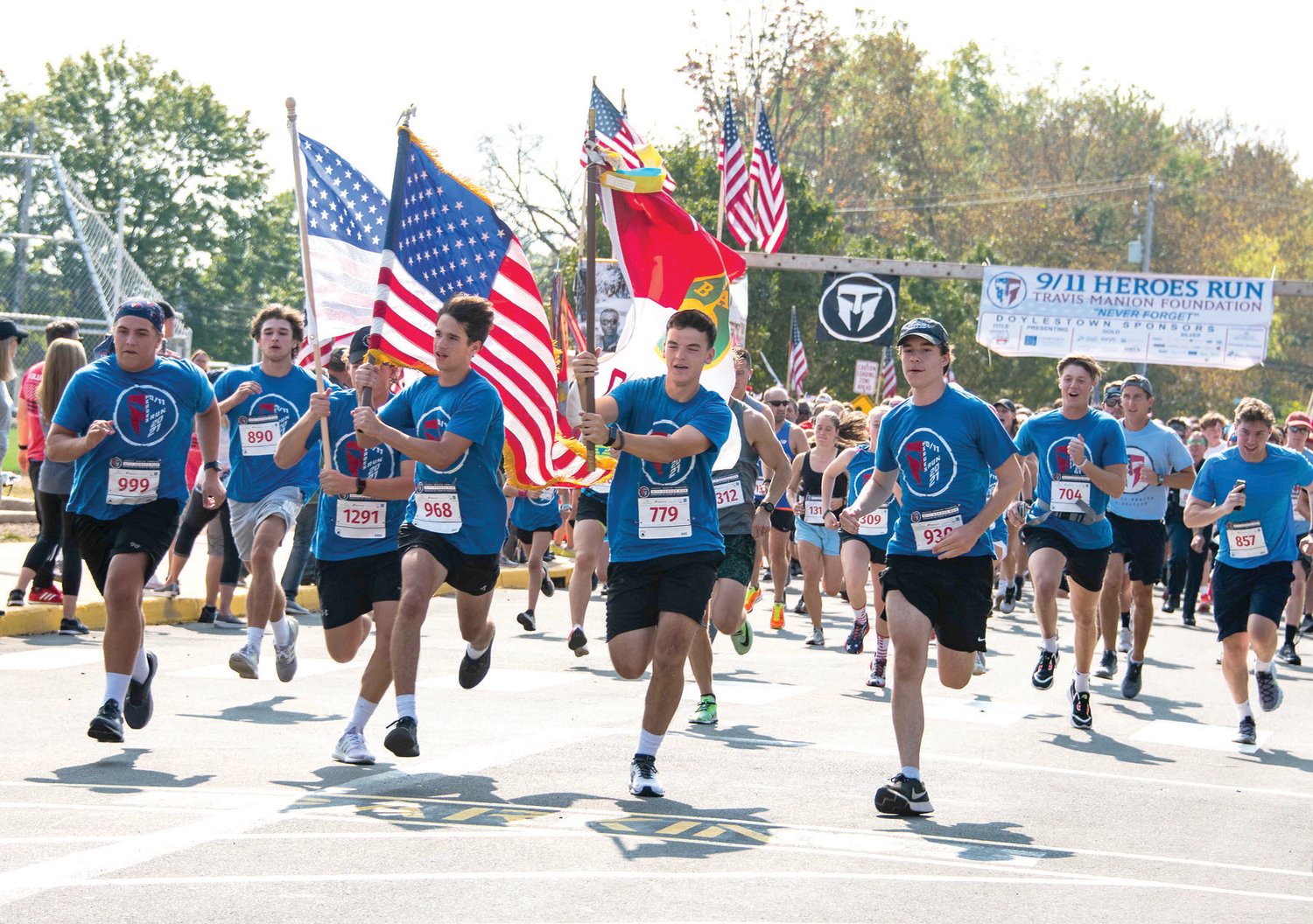 Flag carrying runners take off at the start of the 9/11 Heroes Run in Doylestown Oct. 3.