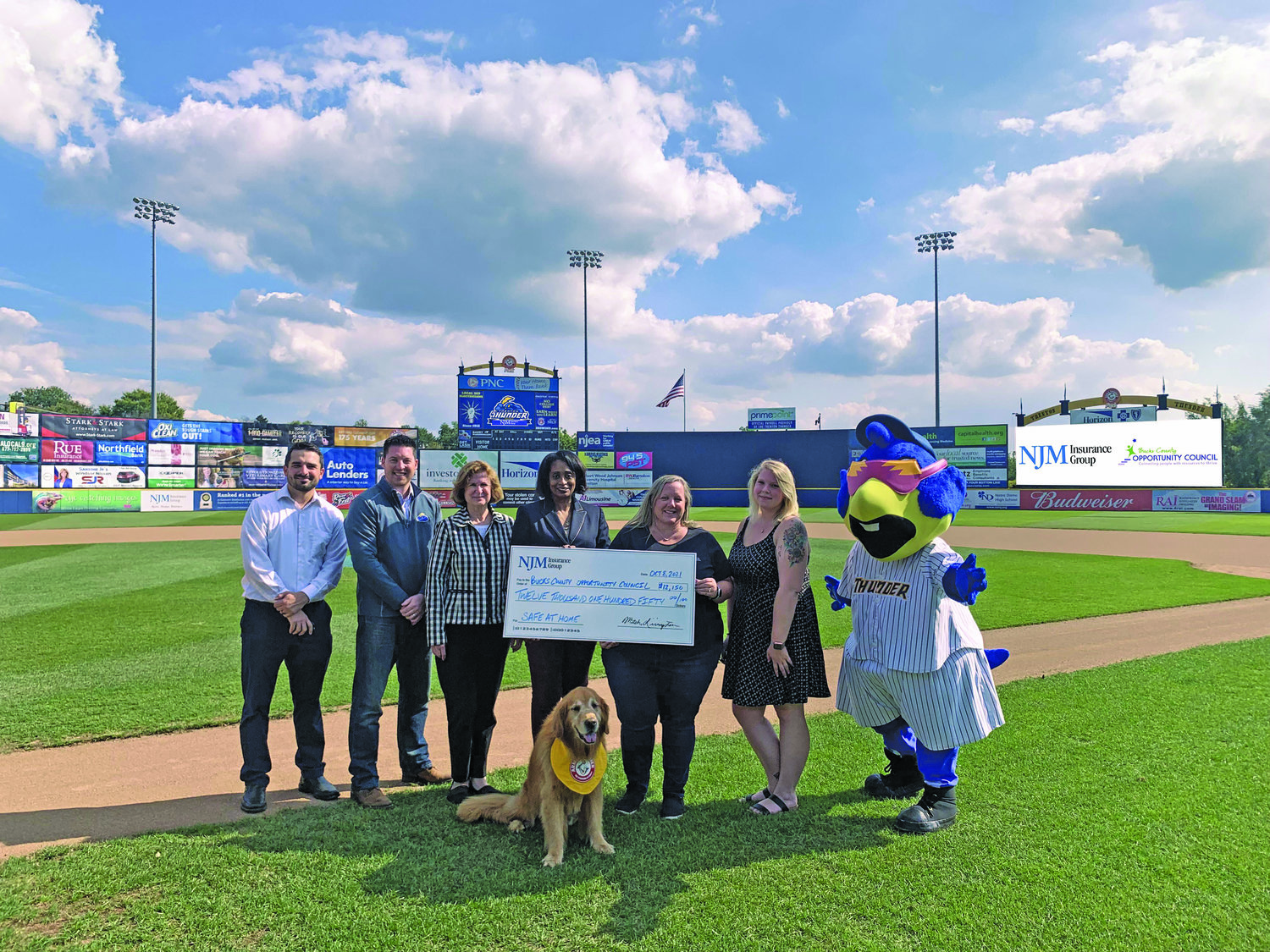 From left are Jeff Richardson (NJM community outreach & events coordinator), Jeff Hurley (Trenton Thunder’s general manager & COO), Pat Hartpence (NJM corporate giving officer), Linda Coles (NJM’s media relations manager), Erin Lukoss (Bucks County Opportunity Council’s CEO/executive director), Connie McGarvey (Bucks County Opportunity Council’s PR & communications coordinator), Boomer. Front and center: Rookie.