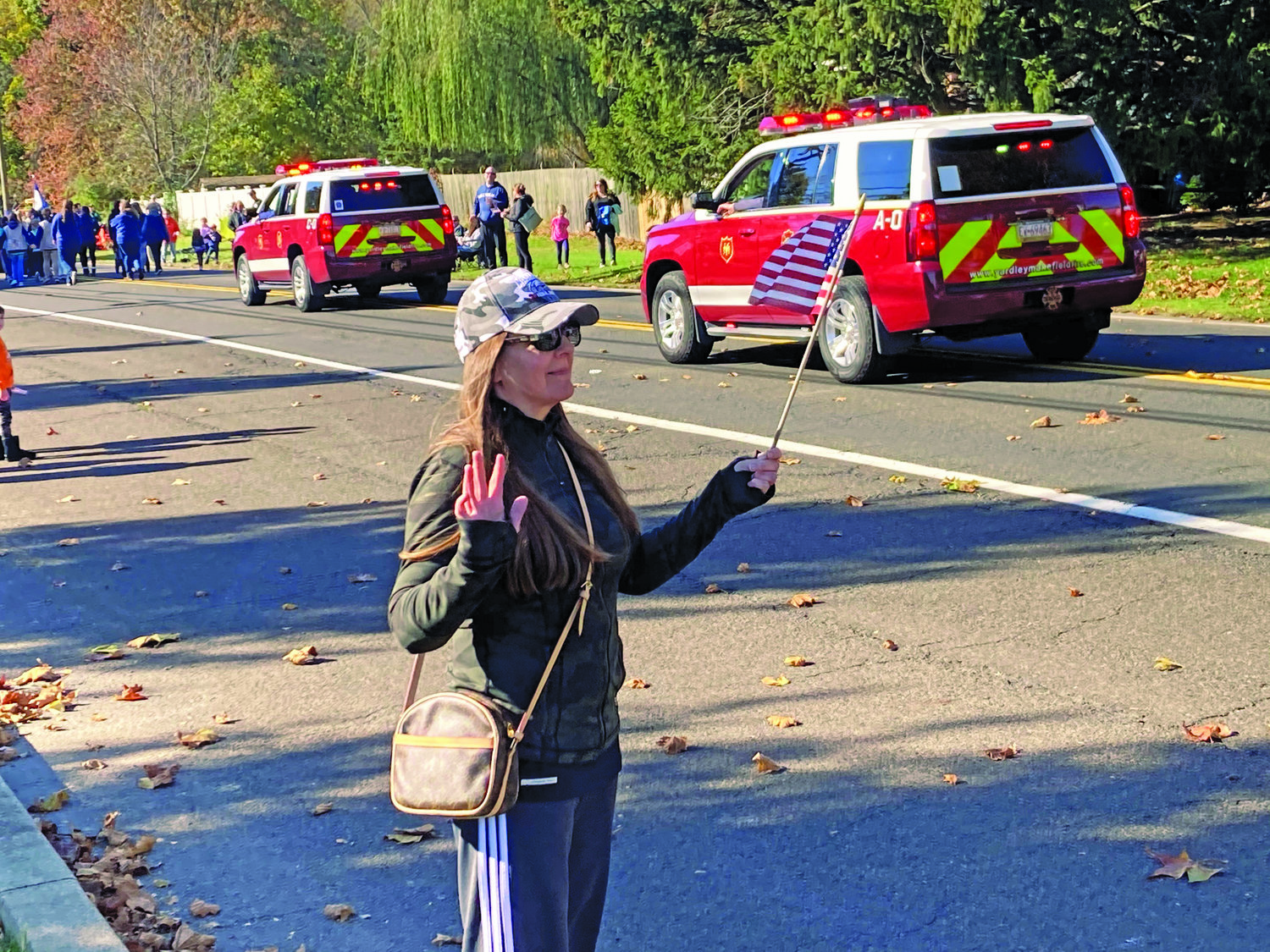 Lower Makefield Township resident Patti Young proudly holds an American flag and waves to participants during the township’s Veterans Day Parade.