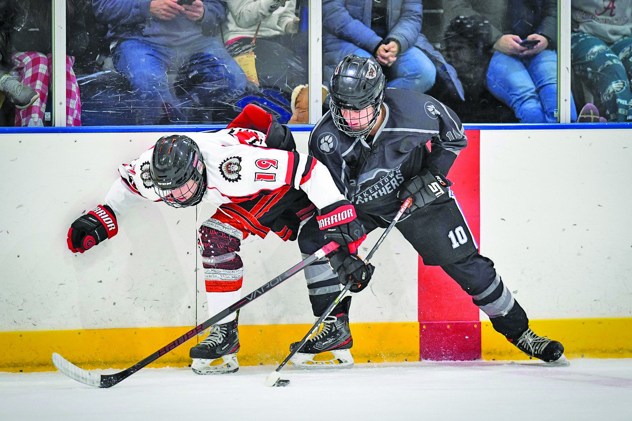 Quakertown’s Anthony Pagliei hip checks Souderton’s Seth Grossman away from the puck.