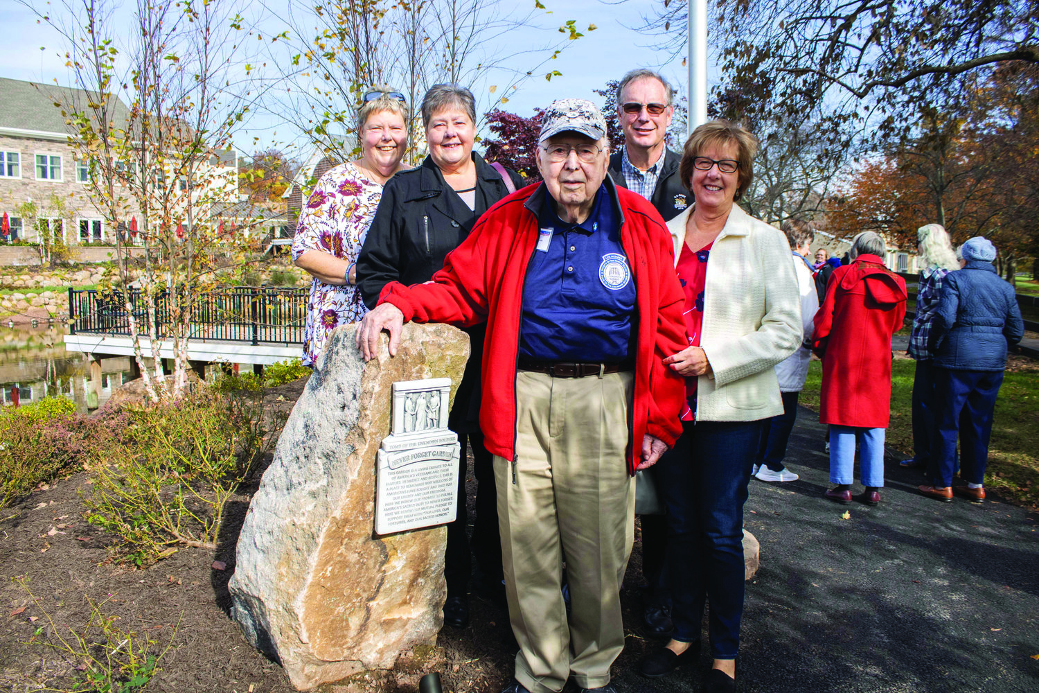 Tom Barnett, veteran and resident of Pine Run Retirement Community in Doylestown Township, stands in the Never Forget Garden with his family.