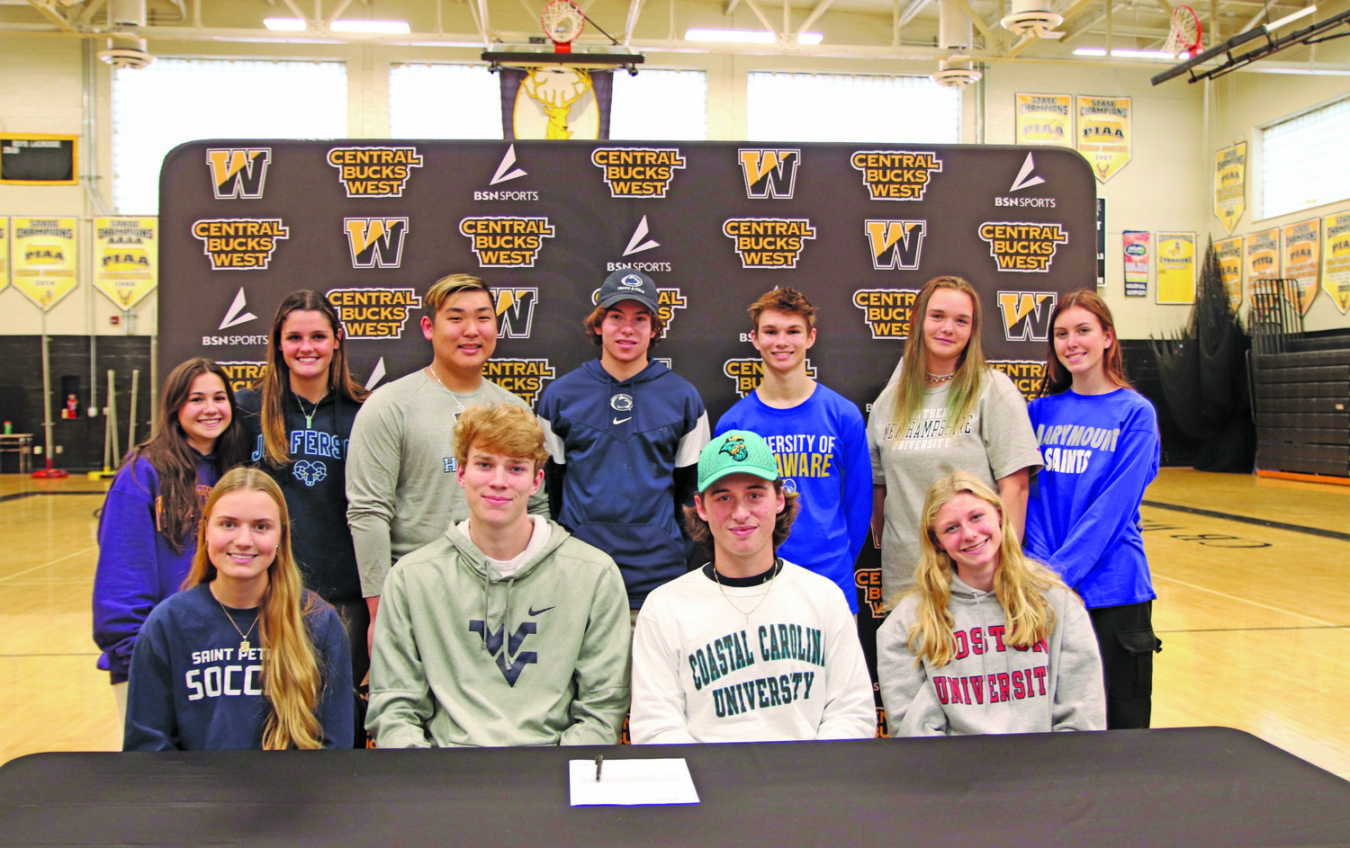 Central Bucks West seniors who were recently recognized for committing to compete in collegiate sports are, from left, front row, Taylor Moyer, Cole Fehrman, Aidan Quinn, Kate Edenson; back row, Bella Aulisio, Emily Spratt, Aiden Kim, Carter Fitzgerald, Kevin Siegfried, Abby Lineman and Bailey Demusz.