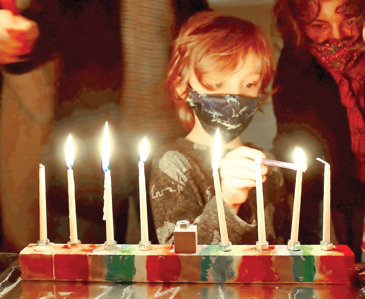 Fielding Strumfels, 5, lights the candles on his menorah.