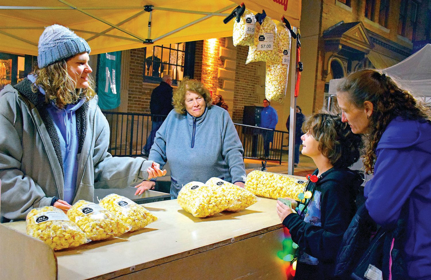Kristin Barrett and Janet Seip of J&J Kettle Korn share their kettle corn with Julie and Kierra Cassel of Quakertown.
