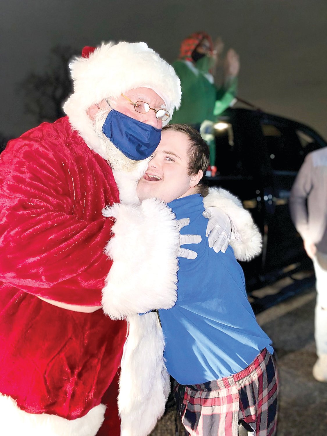 A resident of Woods Services gets a hug from Santa.