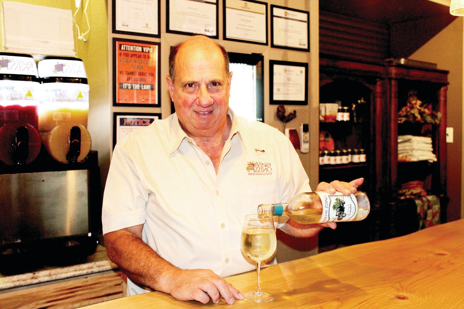 Lou Carrozzino pours wine in his tasting room.