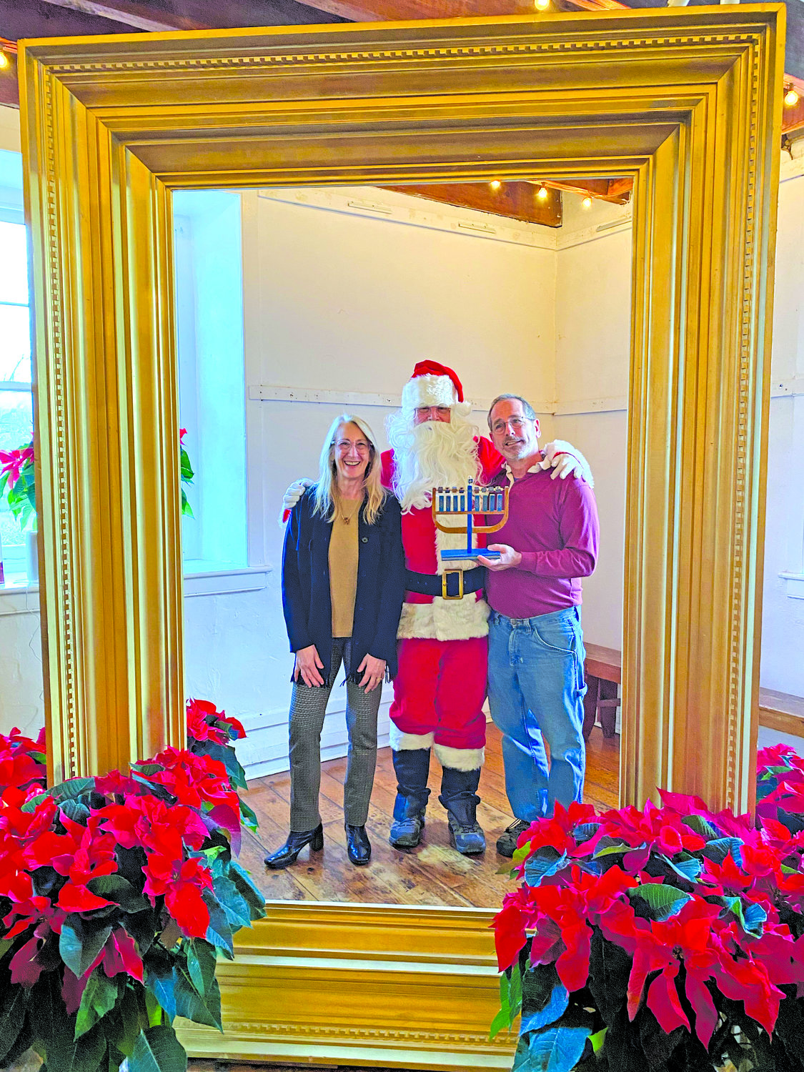 Andrea Mergentime, Rick McDaniel as Santa, and Andy Cleff, holding a menorah.