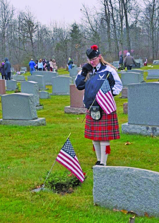 Michele, bagpiper who took part in the ceremony, pays her respects.