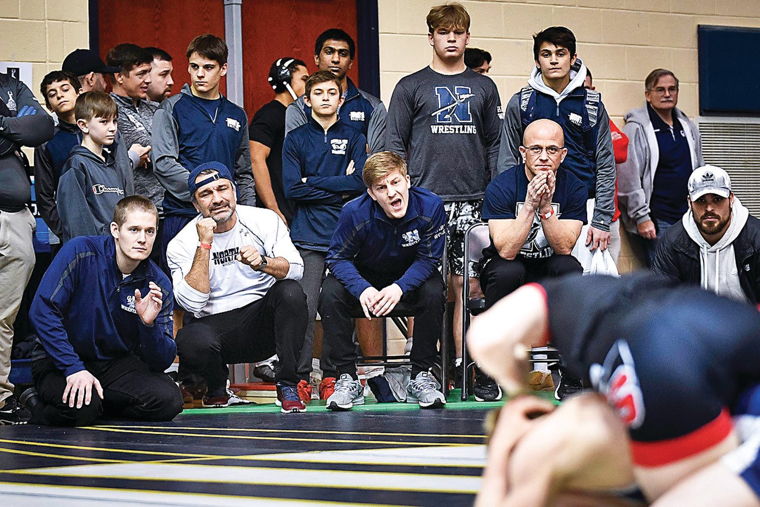 Coaches from the Council Rock North wrestling team shout instructions during Tony Burke’s 113-pound triple overtime 5-3 loss to Holden Huhn of La Salle (Cincinnati).