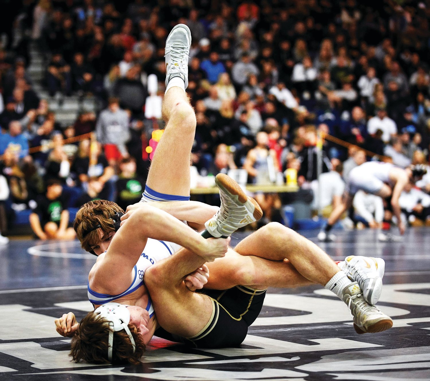 Quakertown’s Todd McGann gets flipped over by Mateo Sgambellone of St. Joseph Regional in the 132-pound weight class. McGann would go on to lose the match by an 8-6 decision.