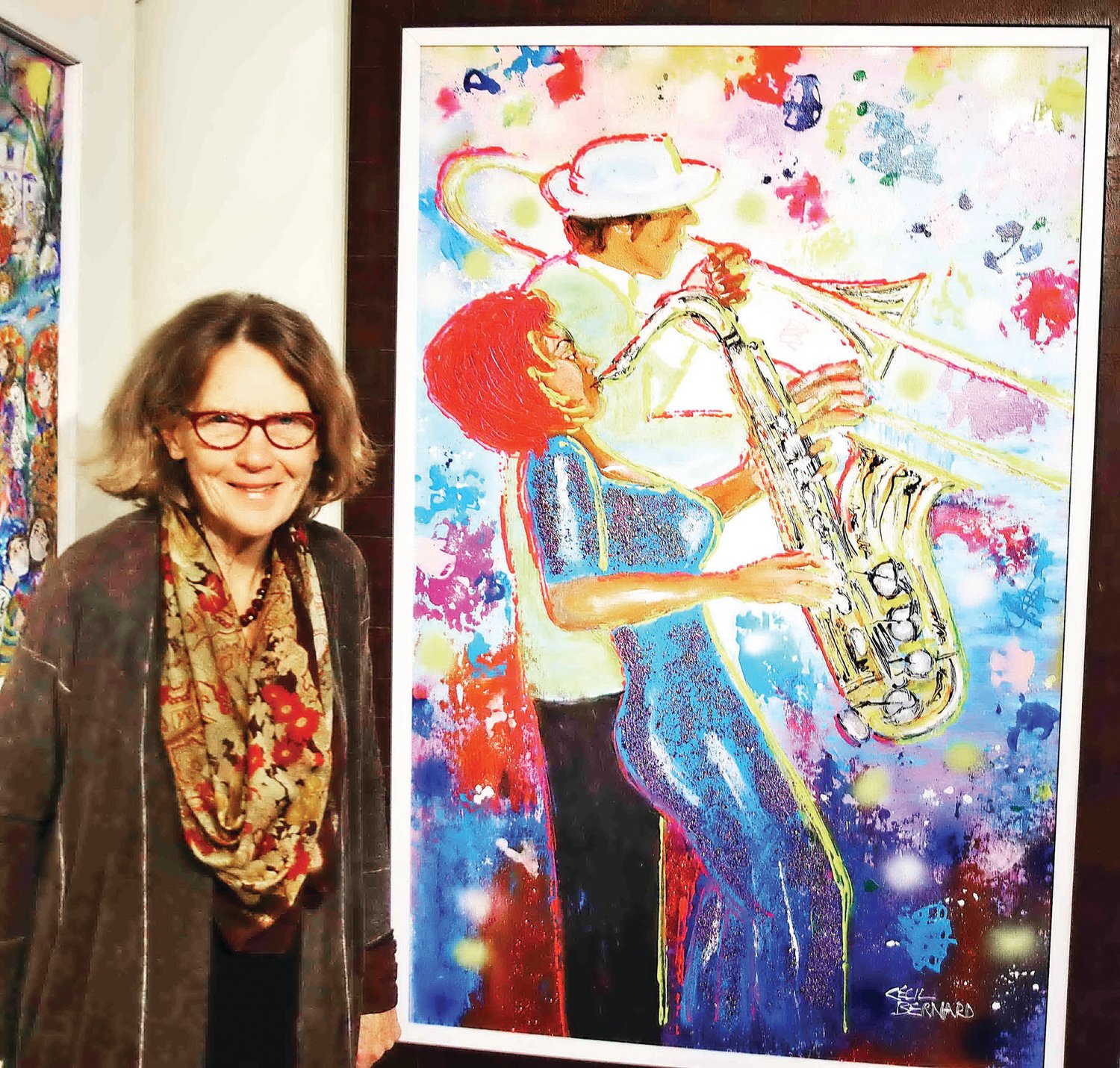 New Hope Arts Center Executive Director Carol Cruickshanks with a painting by Cecil Bernard titled “Bourbon St Duet,” in acrylic on paper.