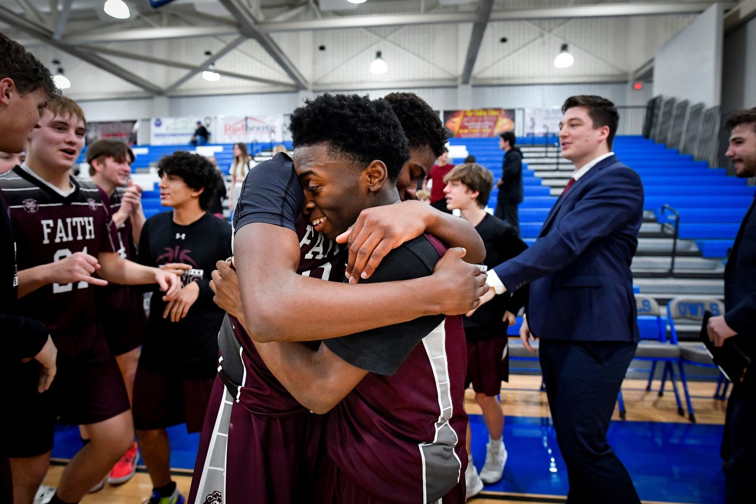 Faith’s Gerald Pinkney gets a hug after the final buzzer from Chris Evans.
