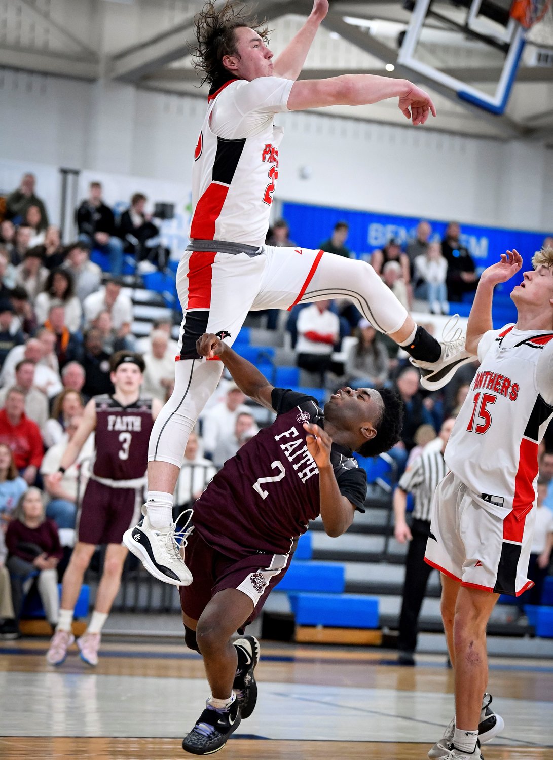 Plumstead’s Jackson Mott soars over Faith’s Gerald Pinkney while going after a rebound.