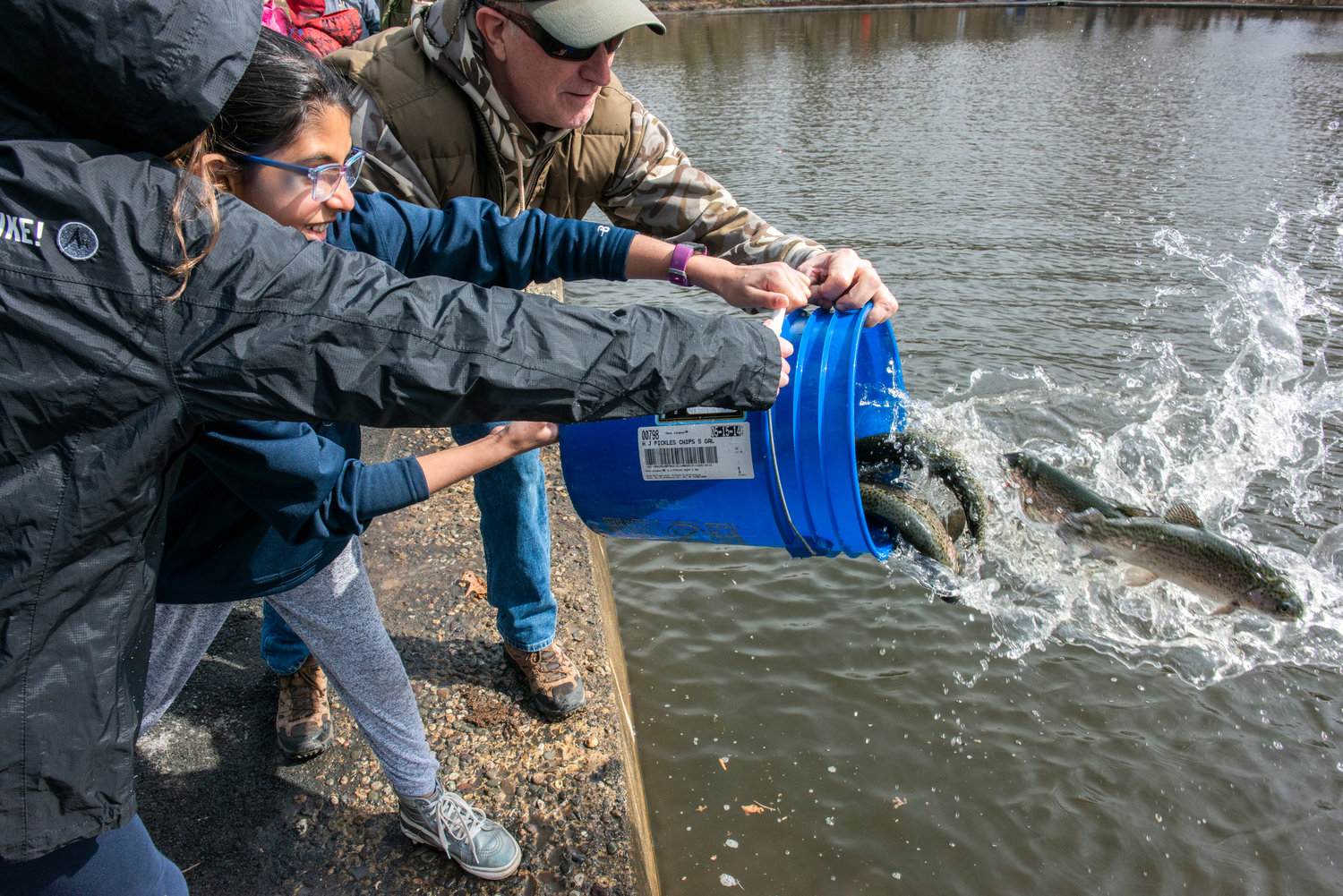 Students get assistance in releasing fish.