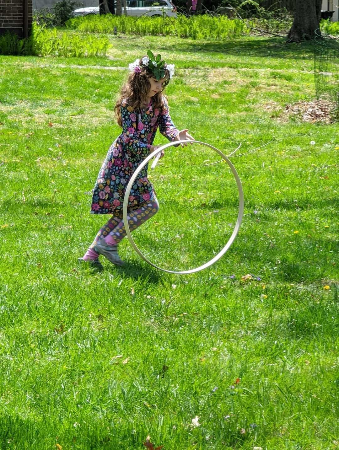 Young Sarah Deans demonstrates how to roll a hoop.