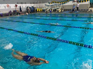 Participants in the 2022 CB East swim clinic work on their backstroke technique.