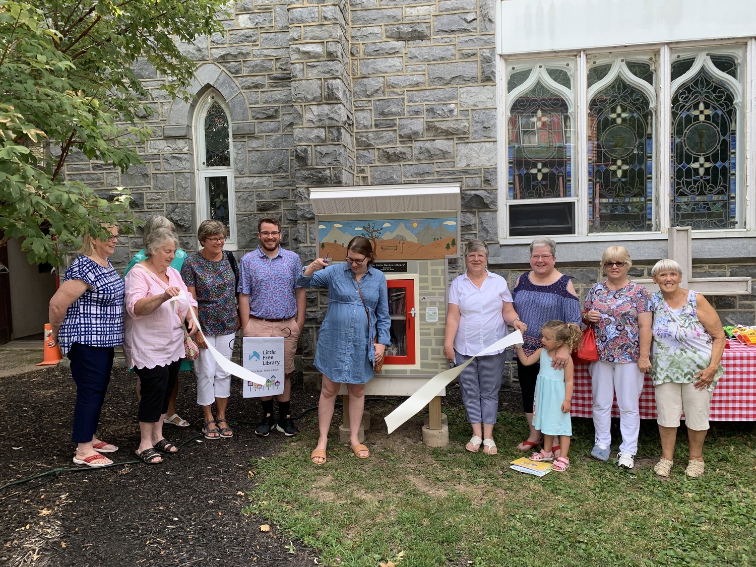 The Rev. Trudy Irving (center right, white shirt) and members of St. Paul’s UCC – Sellersville cut the ribbon on the community’s newest free library box.