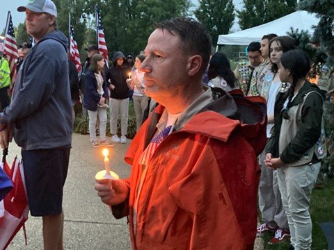 Chris Bazybola of MIddletown Township holds his candle while listening to “God Bless America” during the closing vigil of a Sept. 11 remembrance ceremony at the Garden of Reflection in Lower Makefield Township.