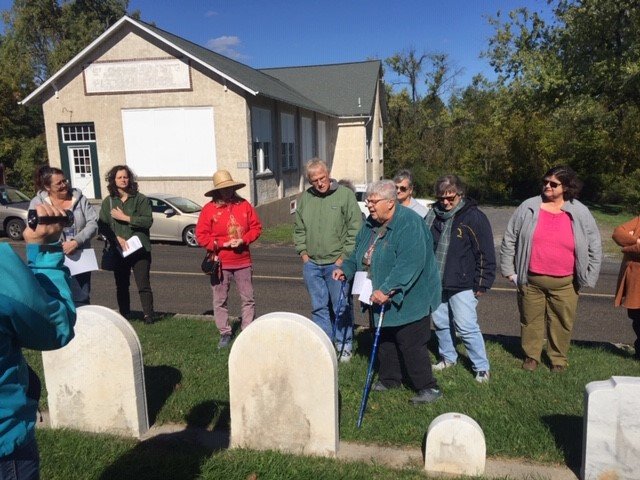 Rosanne McCarty (in green jacket) talks about the history of some Upper Bucks pioneers as she conducts a tour through the oldest section of Old St John’s Catholic Cemetery.