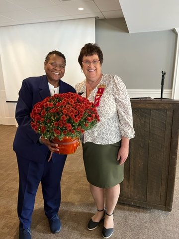 Dr. Felicia Ganther, left, receives flowers from Kathy Simmons, co-president of Delta Kappa Gamma Alpha Nu at Bucks County Community College.
