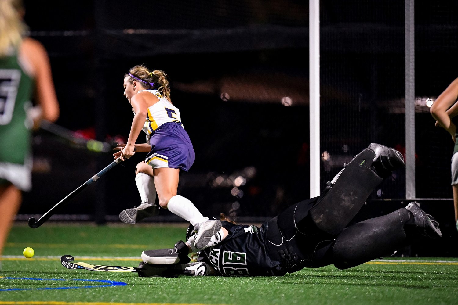 New Hope-Solebury’s Ava Cozza jumps over Dock goalie Haley Harper as she tries to get a shot late in the fourth quarter.
