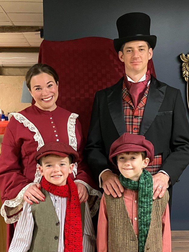 The Cratchit Family: Mrs. Cratchit, Alyssa Moore; with Tiny Tim, son Jacob Moore and Bob Cratchit, Lee Damon; with Tiny Tim, son Ryker Damon.