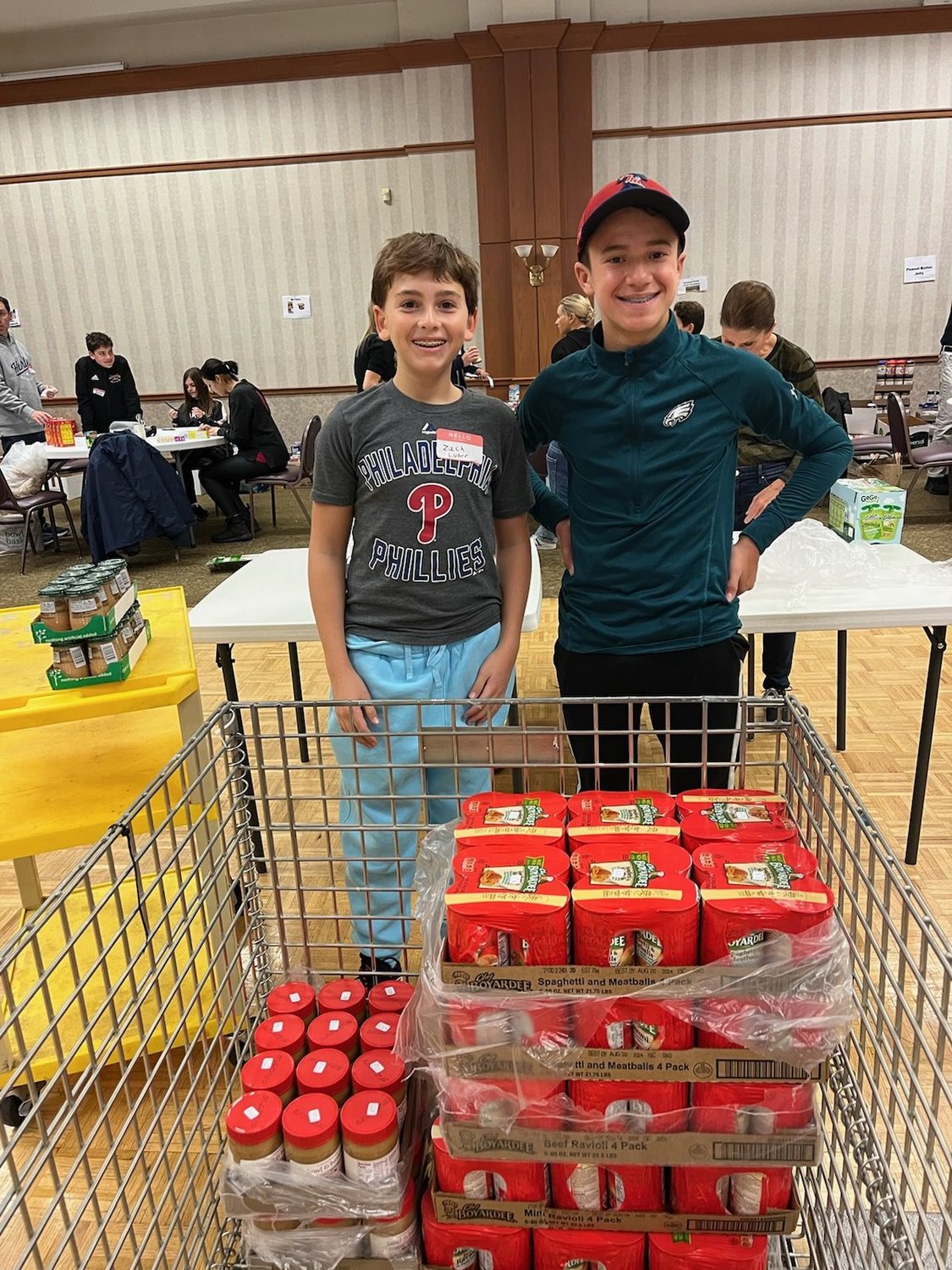 Students, adults and families participated in a food sorting event at Shir Ami Reform Synagogue of Newtown in October. Helping to sort, label and transport over 15,000 pounds of donated food were Zach Luber, 13, left, and Jeremy Leon, 13, both of Newtown.