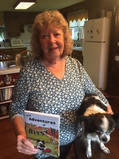 Bonita Waitl shows her book and its subject, the mixed breed Bitsy, twice adopted and much loved.