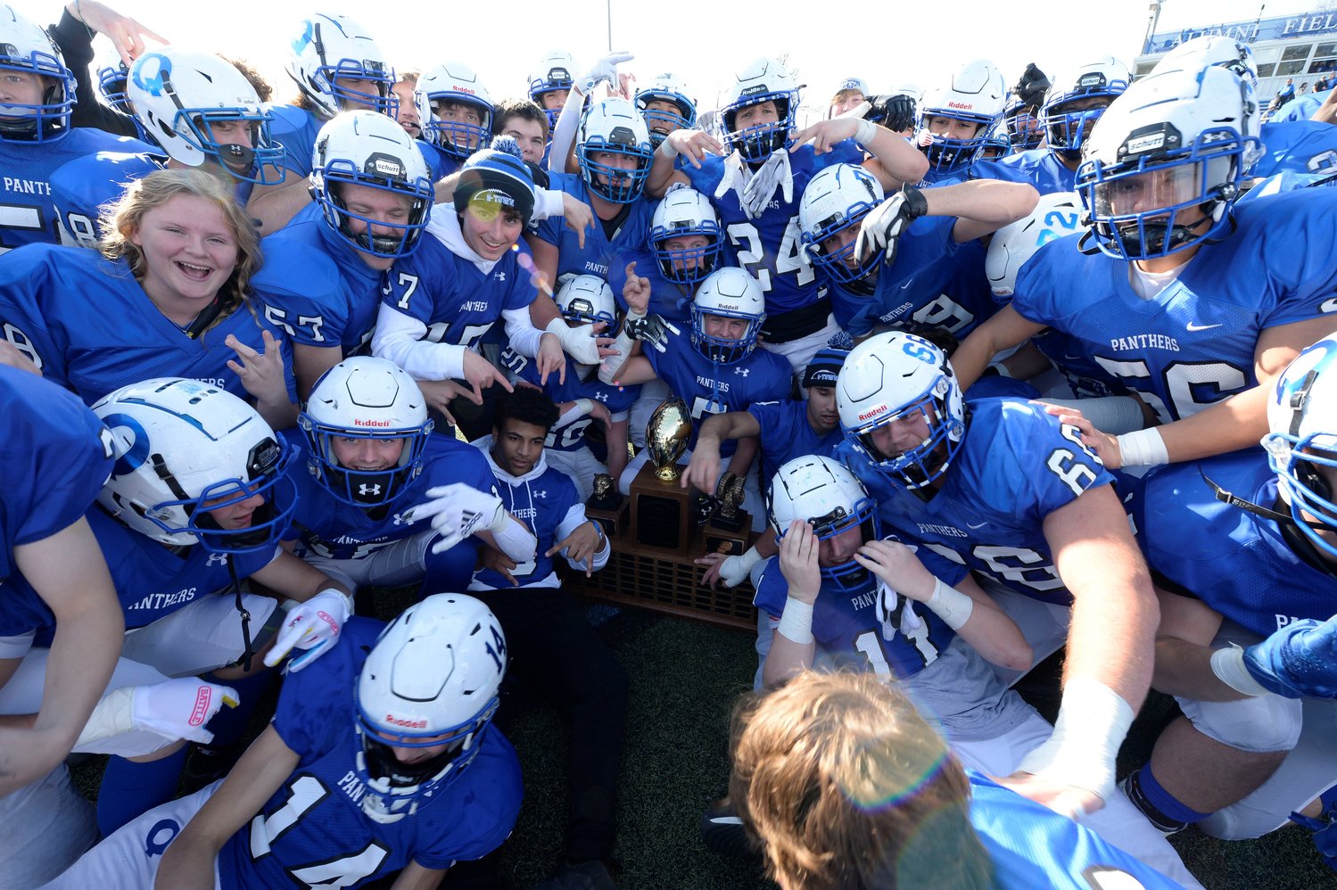 The Quakertown Panthers celebrate with the Thanksgiving Day rivalry trophy.