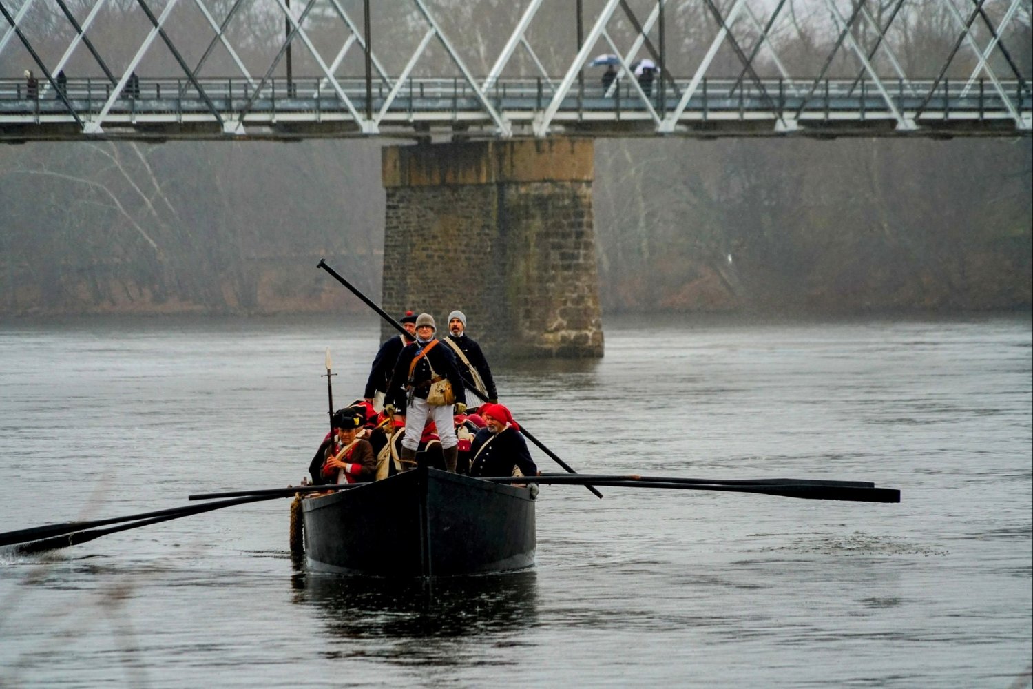 Reenactors row across the Delaware River in a Durham boat.