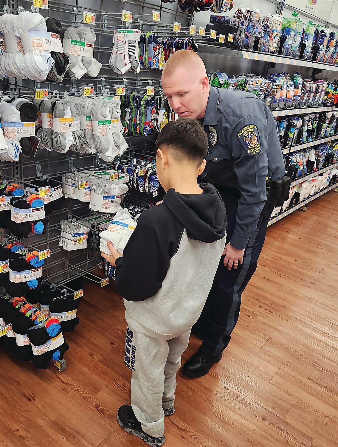A Franconia police officer helps a child shop for socks and other items.