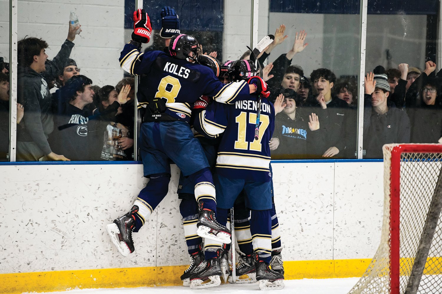 CR South players mob Chase Tovsky after scoring the fifth goal as the student section cheers from behind the net.