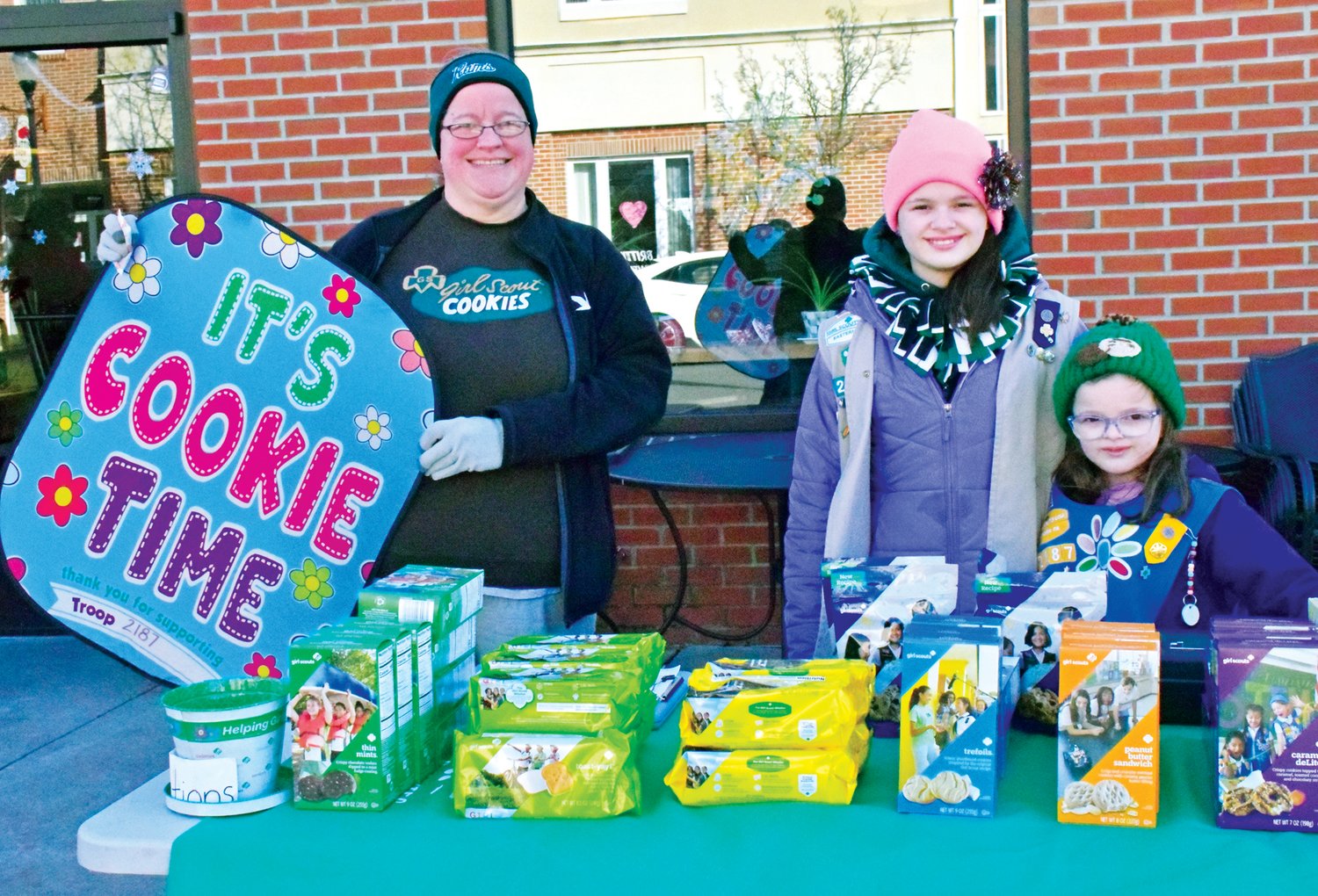 Megan Dean, left, and daughters Anna and Paige of Girl Scout Troop #2187 sell Girl Scout cookies on the sidewalk outside of Rise & Grind Cafe in Perkasie during the 'Winter Wanderland' celebration in downtown Perkasie on Jan. 28.
