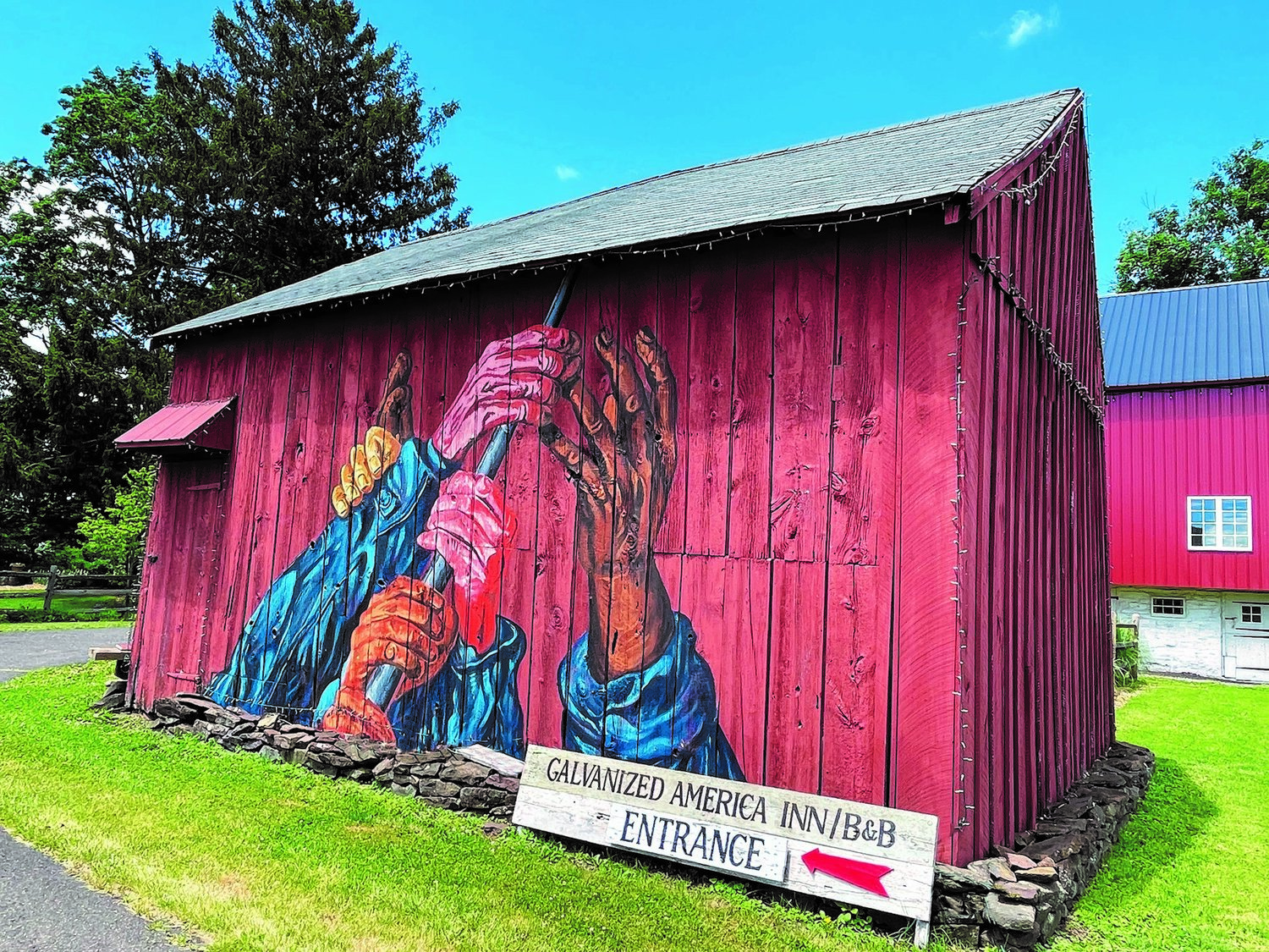 Bedminster artist Ed Bennett’s mural on the side of his barn evokes a message of inclusivity and diversity. To conclude the work, Bennett will mount an American flag on the roof right above the pole the hands are grasping.