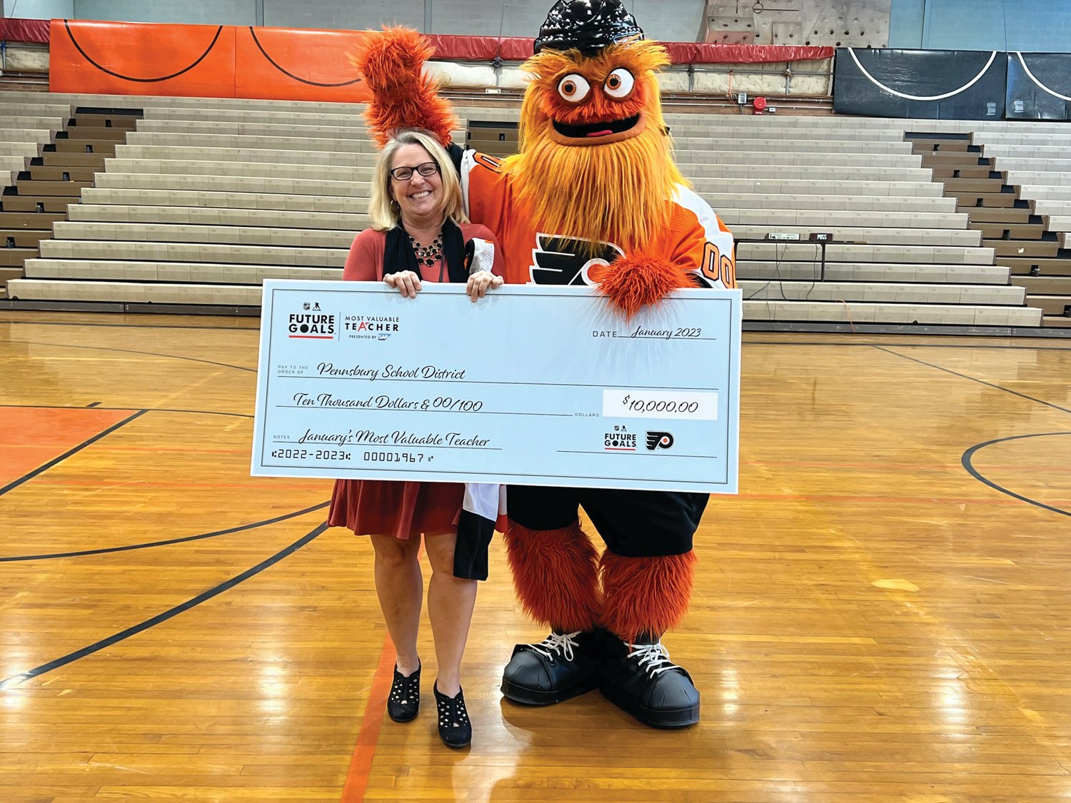 Philadelphia Flyers
Flyers mascot Gritty presents Charles Boehm Middle School teacher Sandy Metzger with a check to be used toward sustainability initiatives in the Pennsbury School District.