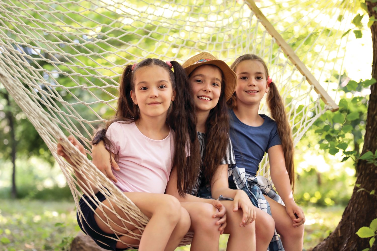 Little girls in hammock outdoors.